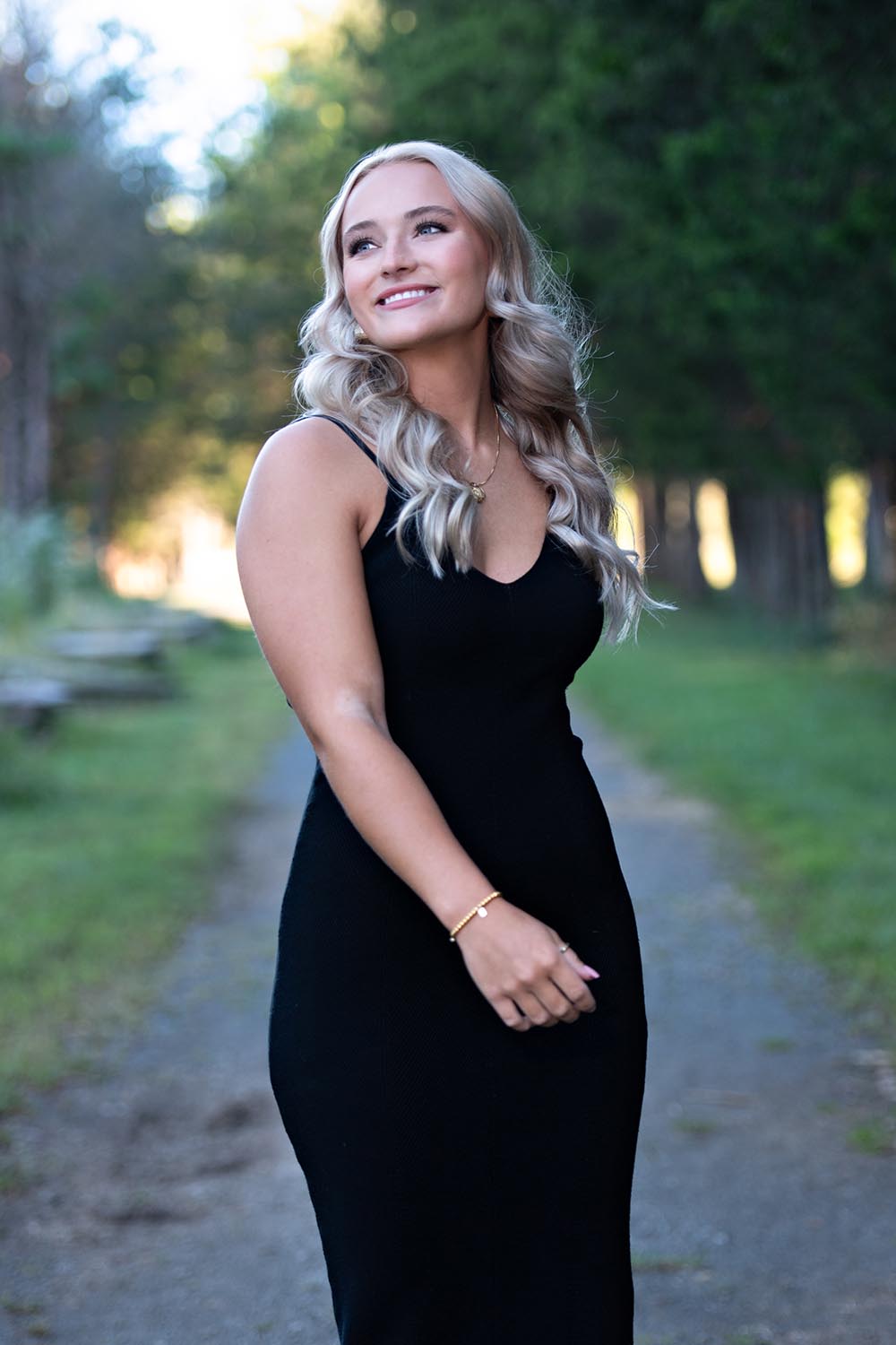 A high school senior girl posing in gravel walkway.