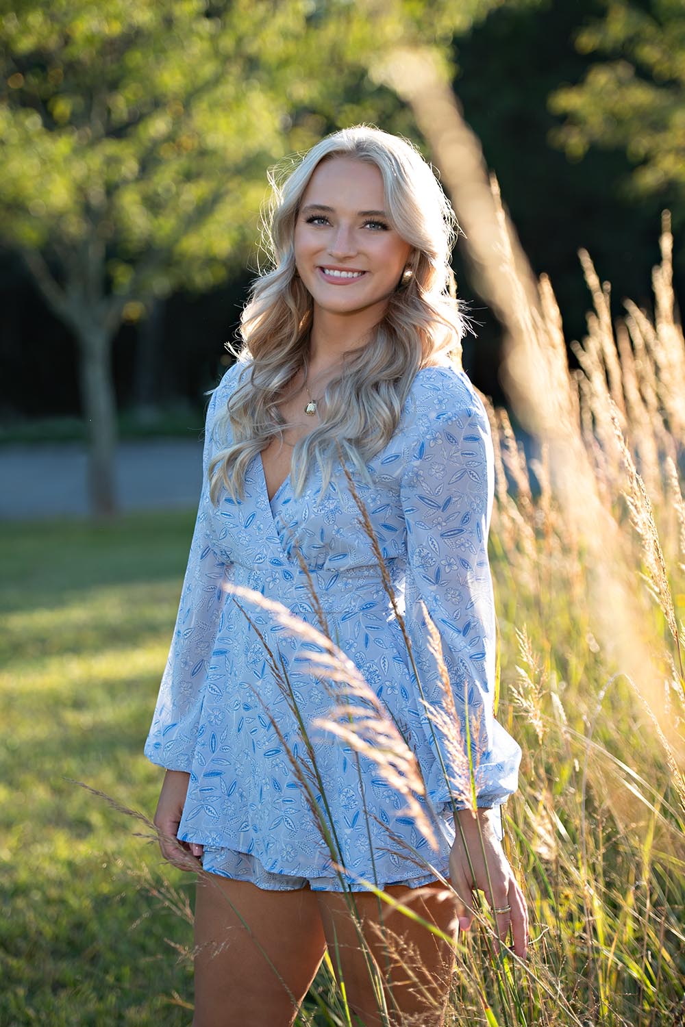 A high school senior girl standing in sunny field